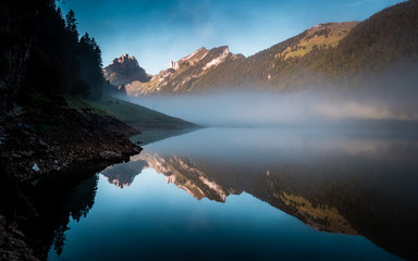 amazing water reflection in clear moutain lake during sunrise morning switzerland