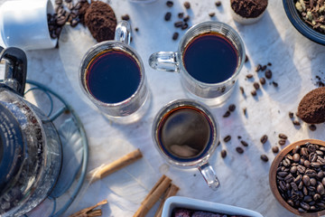 above view of mugs of hot black coffee still life with whole coffee beans, ground coffee, coffee grinder