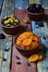 Mix of different varieties of dried fruits on wooden background - dates, apricots, prunes, raisins. Organic healthy food. Excellent snack or dessert
