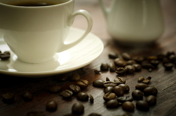 Coffee beans, glass and equipment for drinking coffee with warm light
