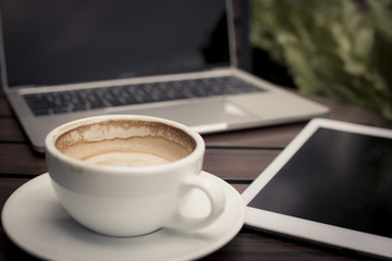 coffee on table with laptop working in cafe, relax and free time concept