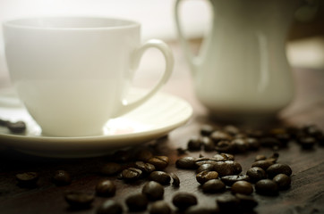 Coffee beans, glass and equipment for drinking coffee with warm light