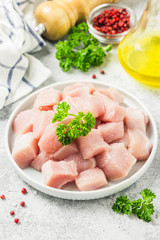 Raw meat cubes in a bowl with parsley, seasonings and olive oil. Selective focus, space for text.