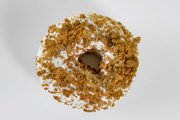 Donut sprinkled with crumbled cookie,  white background