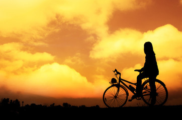 Fototapeta na wymiar Silhouette woman with bicycle, walking, sunset background