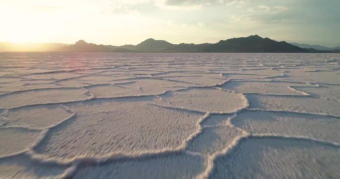 Sun sets on the horizon over a desert of salt in Utah