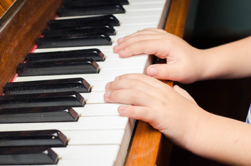 Fototapeta premium little boy plays a piano