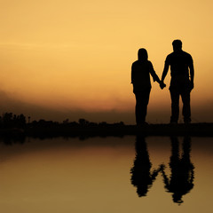 Fototapeta na wymiar silhouette of couple on the beach at sunset