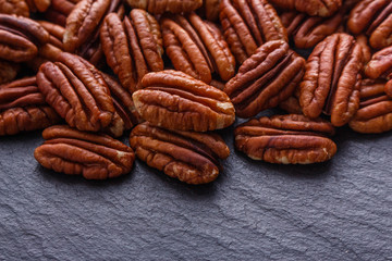 delicious pecan nuts on a dark stone background