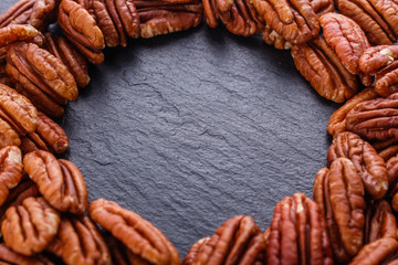 delicious pecan nuts on a dark stone background