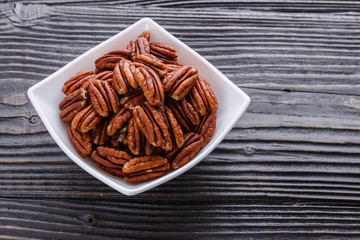 delicious pecan nuts on a rustic wooden background