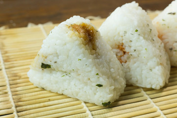 The Japanese food Onigiri  white rice formed into triangular or cylindrical shapes and often wrapped in nori.