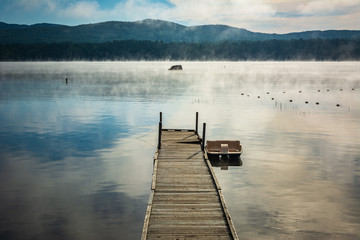 Obraz premium Foggy morning view of Webb Lake from Mt. Blue State Park campground