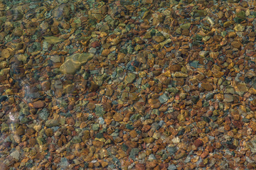 Background of colorful stones under the sea water.