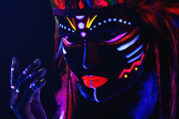 Fototapeta na wymiar Woman with a neon makeup in ultraviolet light