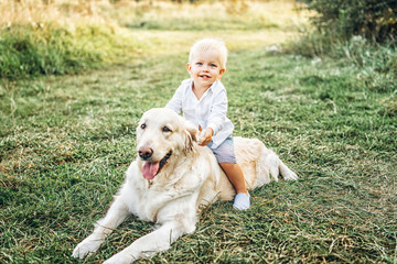 Pretty little baby boy have fun with dog