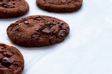 Close up picture of dark chocolate cookies on baking papre