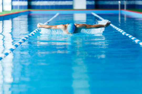 Image of sports man swimming along path in pool