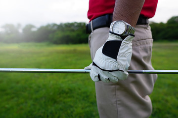 The golfer holding a golf club to hit a golf ball