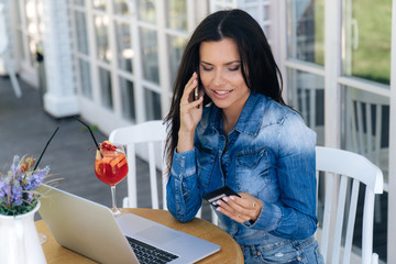 Close-up of an attractive smiling girl calling the bank, wants to solve some issues with a credit...