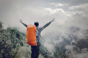 young adventurer, hiking on a mountain with fog high view beautiful vintage style. at Doi Phu Kha in Nan.