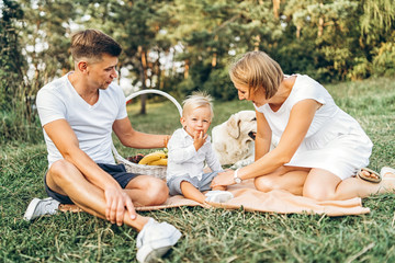 Young cute family on picnic with dog