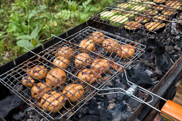 mushrooms champignons baked on a grate over hot coals