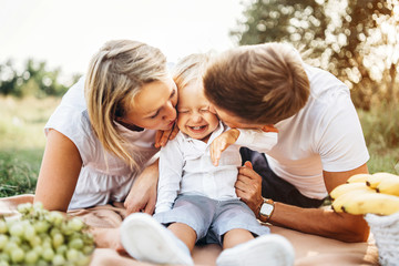 Young parents with little baby boy on picnic outdoor