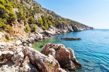 Croatian seashore. Coast of Hvar Island. Greetings from the sea. Sea and rocks in Croatia. Landscape of the Adriatic Sea. Hot summer day.