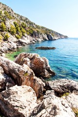 Croatian seashore. Coast of Hvar Island. Greetings from the sea. Sea and rocks in Croatia. Landscape of the Adriatic Sea. Hot summer day.