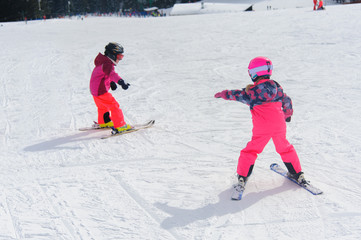 Fototapeta na wymiar Ski instructor teaching young kids to go down ski slope