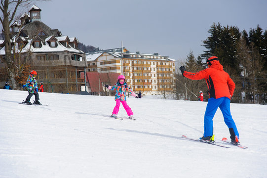 Ski instructor teaching young kids to go down ski slope