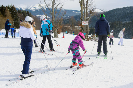 Family skiing on ski resort. Waiting for the piste