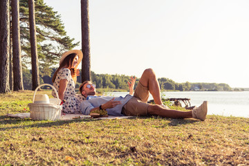 Beautiful couple enjoying picnic time on the sunset