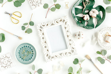 Working space with ceramic sheet monstera, eucalyptus leaf, accessories on white background. Flat position. Top view