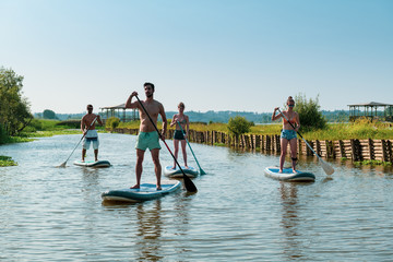 Man and women stand up paddleboarding