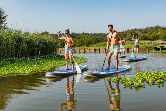 Man and women stand up paddleboarding