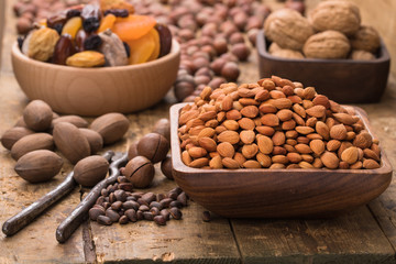 peach kernel peeled in wooden bowl on table, grunge style.