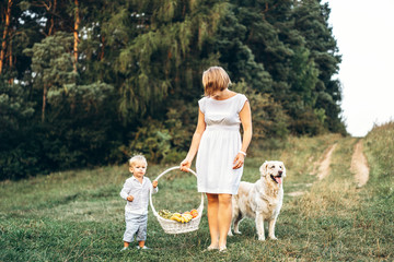 Obraz premium Mother with son and dog on picnic outdoor