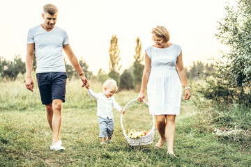 Fototapeta premium Young parents with little baby boy on picnic outdoor