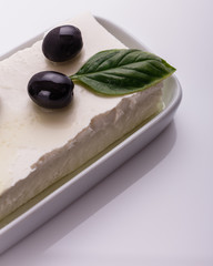 A piece of feta cheese on a white background