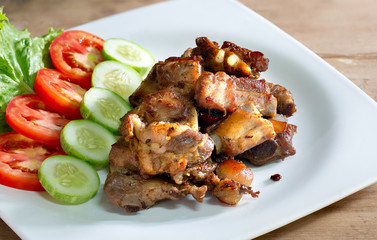 Fried deep pork ribs in white dish with vegetable thai food