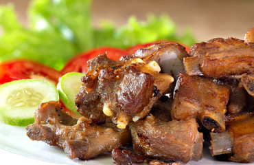 Fried deep pork ribs in white dish with vegetable thai food