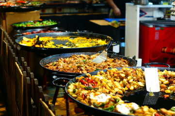 Large Industrial Frying Pans of Different Types of Paella in a European Street Food Market
