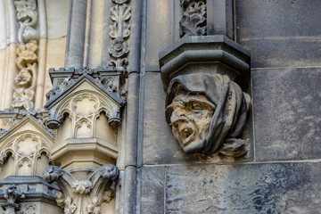 The face of a stone gargoyle in the form of an old woman