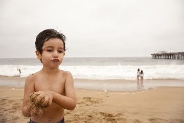 little boy on the beach puckering
