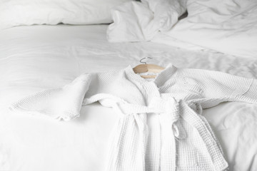 white bath robe on the bed in hotel room