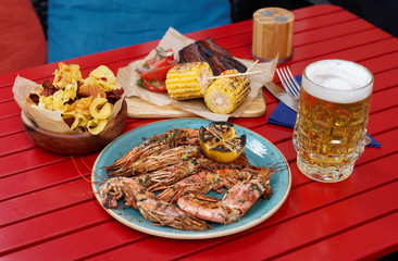 Meat, seafood and potato chips served with beer