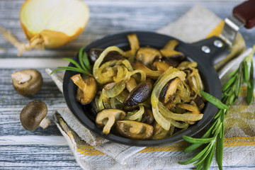 fried Japanese mushrooms shiitake with onions and spices in a frying pan
