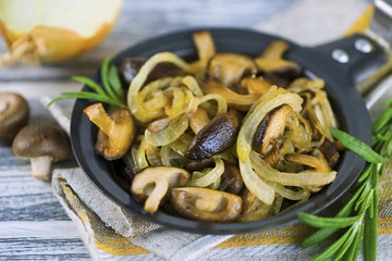 fried Japanese mushrooms shiitake with onions and spices in a frying pan